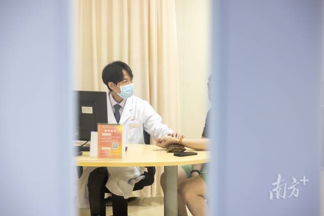 梁偉衡在給病人看診。