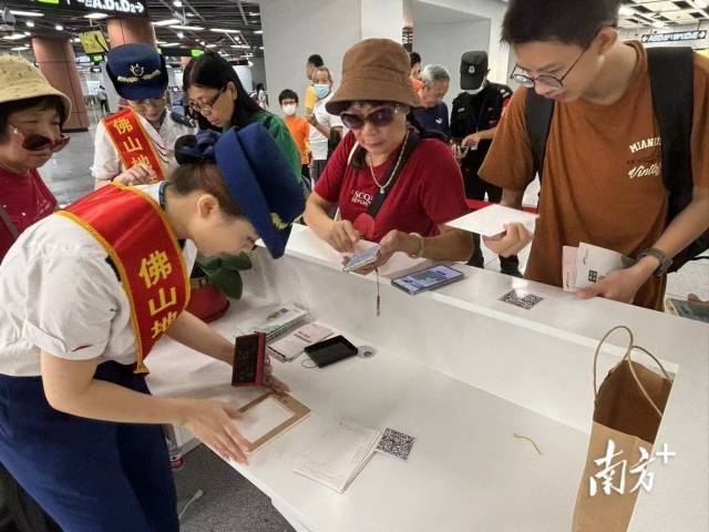 市民在桂城站便民服務臺用明信片蓋章打卡。龍西男 攝