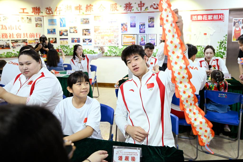 9月2日，在澳門工聯氹仔湖畔綜合服務中心，游泳運動員潘展樂（右）展示與小朋友一起制作的燈籠。當日，內地奧運健兒代表團走進澳門社區，分別到婦聯樂滿家庭服務中心、街總石排灣家庭及社區綜合服務中心和工聯氹仔湖畔綜合服務中心與市民互動。新華社發