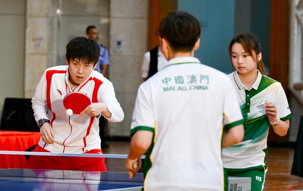 9月1日，乒乓球運(yùn)動(dòng)員王楚欽（左）與澳門運(yùn)動(dòng)員切磋球技。當(dāng)日，內(nèi)地奧運(yùn)健兒代表團(tuán)在澳門奧林匹克體育中心室內(nèi)體育館與澳門青少年運(yùn)動(dòng)員進(jìn)行互動(dòng)交流。新華社記者 郭雨祺 攝