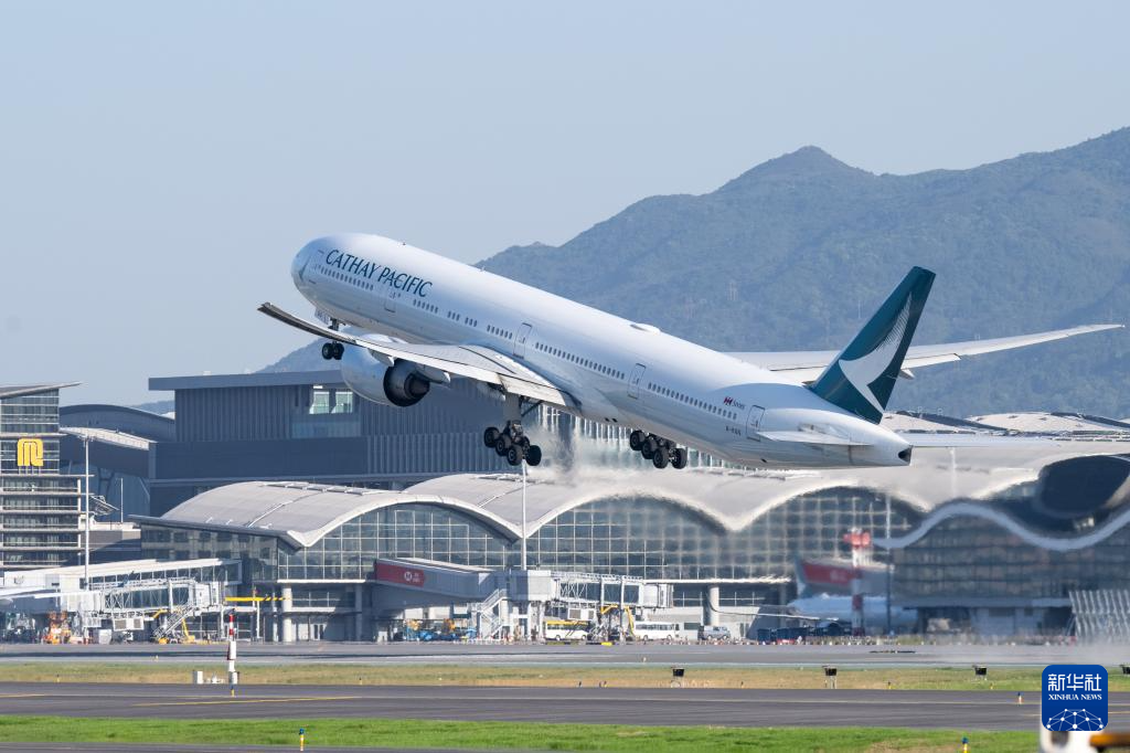 11月28日，香港國際機場三跑道系統(tǒng)正式啟用后，一架飛機從中跑道起飛。新華社記者 朱煒 攝