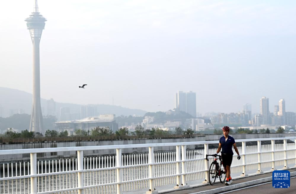 市民推著自行車行走在澳門嘉樂庇總督大橋上（11月17日攝）。