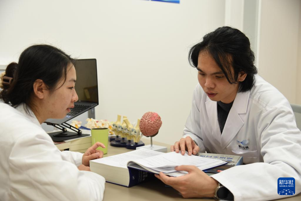 澳門醫生繆永銳（右）和同事進行交流（12月17日攝）。新華社記者 洪澤華 攝