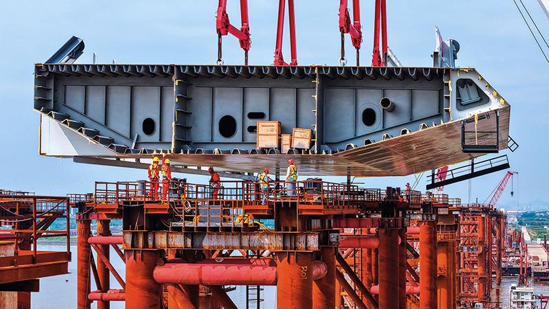 施工人員在位于廣州南沙區(qū)的萬龍大橋鋼梁支架上接收首節(jié)鋼箱梁（2025 年 4 月 29 日攝） 劉大偉攝 / 本刊