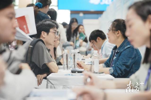 “百萬英才匯南粵”武漢招聘會現場火爆，企業招聘展位座無虛席，面試洽談對接需求。