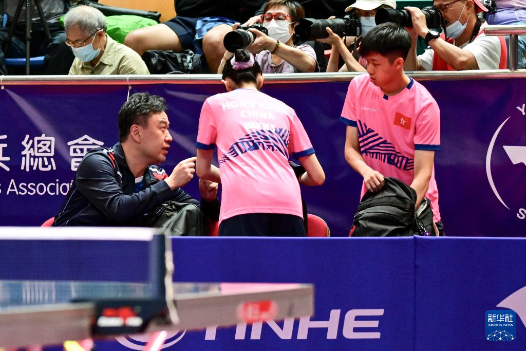 7月31日，孟憲儉（左）在香港舉行的一場青少年乒乓球比賽中指導球員。新華社記者 朱煒 攝