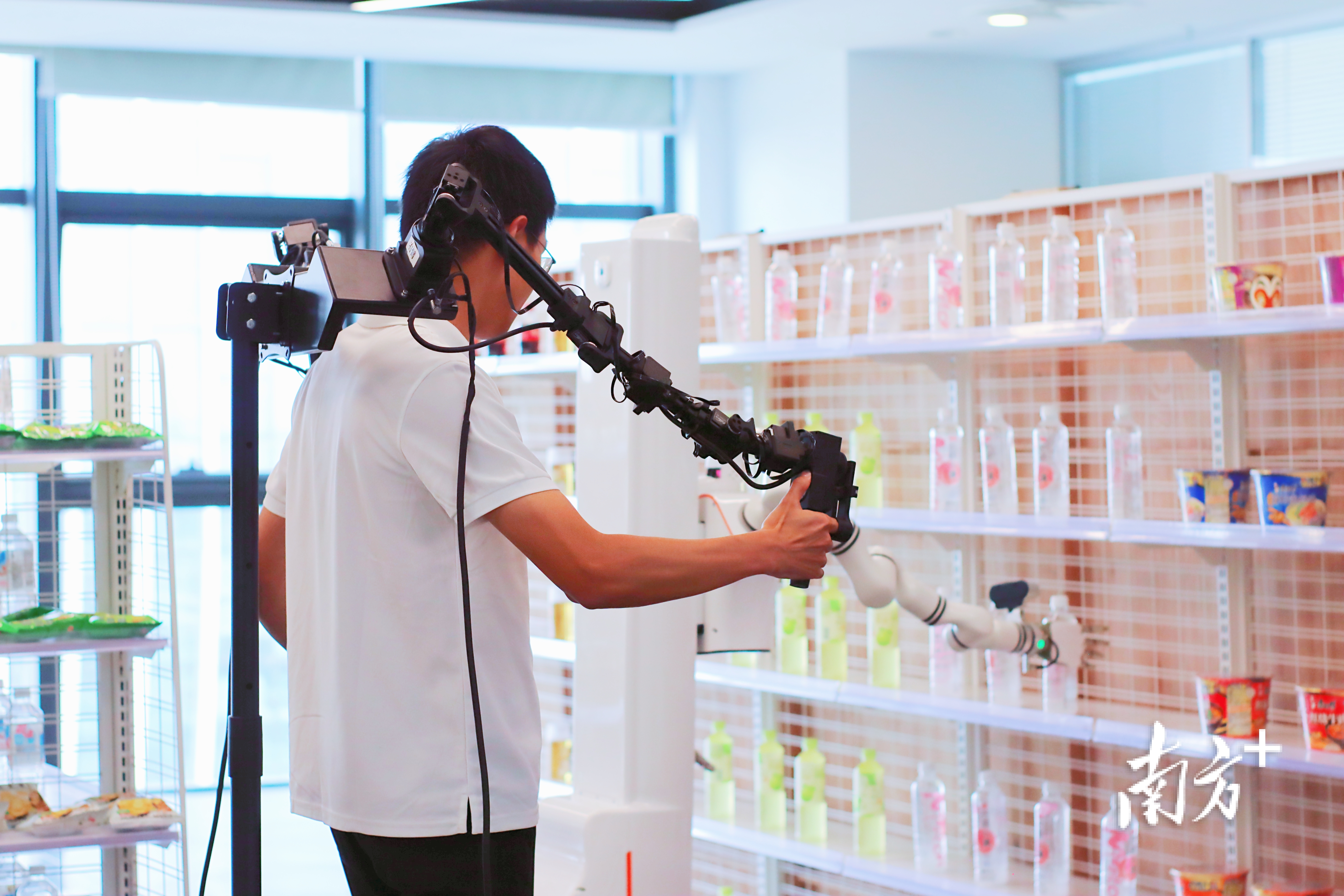 訓練人員正“手把手”教機器人學習分揀物品。