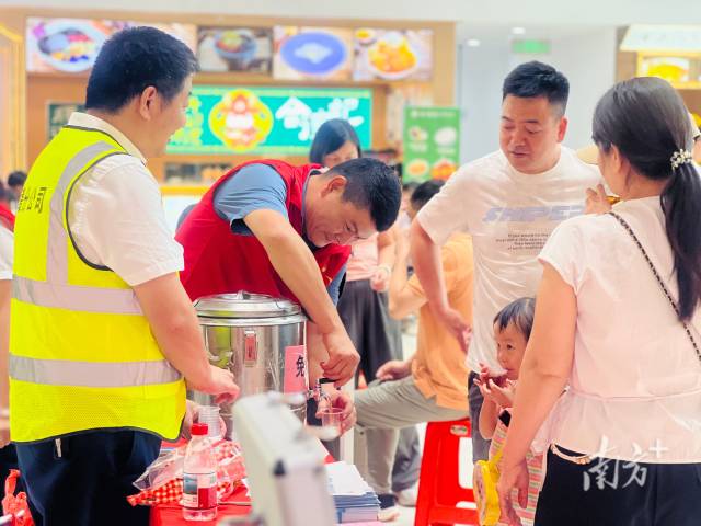 志愿者在服務區為旅客提供志愿服務。