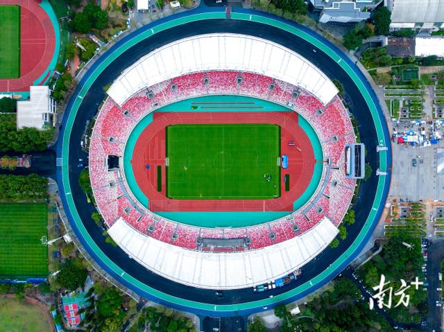 從空中俯瞰，體育中心的停車場上方，一塊塊光伏板有序排布，在陽光下泛著光。