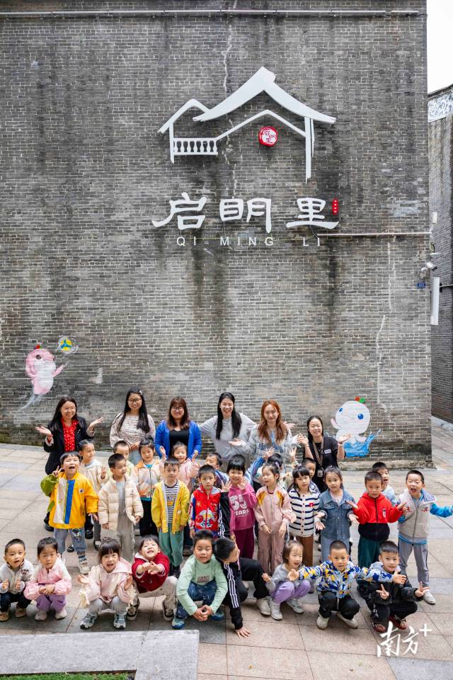 小朋友與吉祥物小海豚墻繪合影留念。