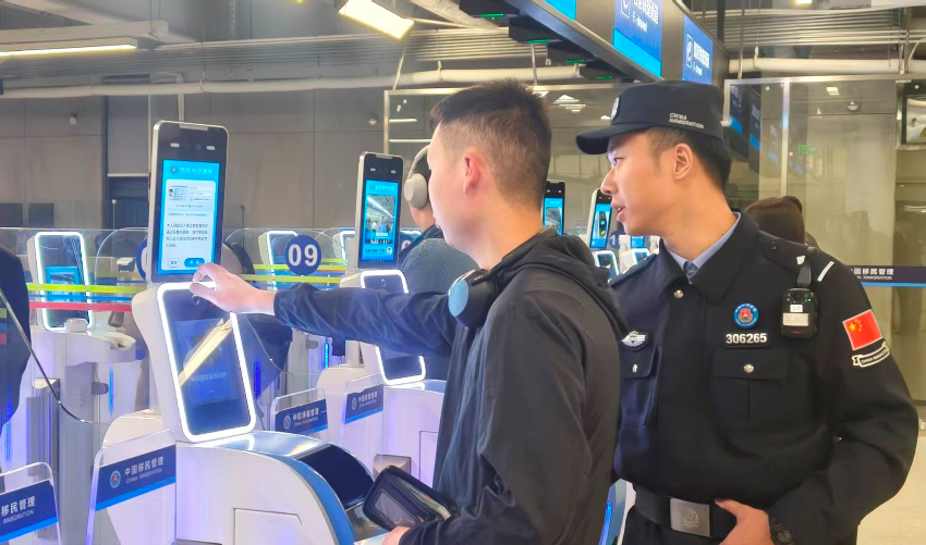 皇崗邊檢站民警指導(dǎo)首次經(jīng)智能快捷通道入境的香港旅客“刷臉”代替“刷證”體驗(yàn)。 通訊員 黃俊生 供圖
