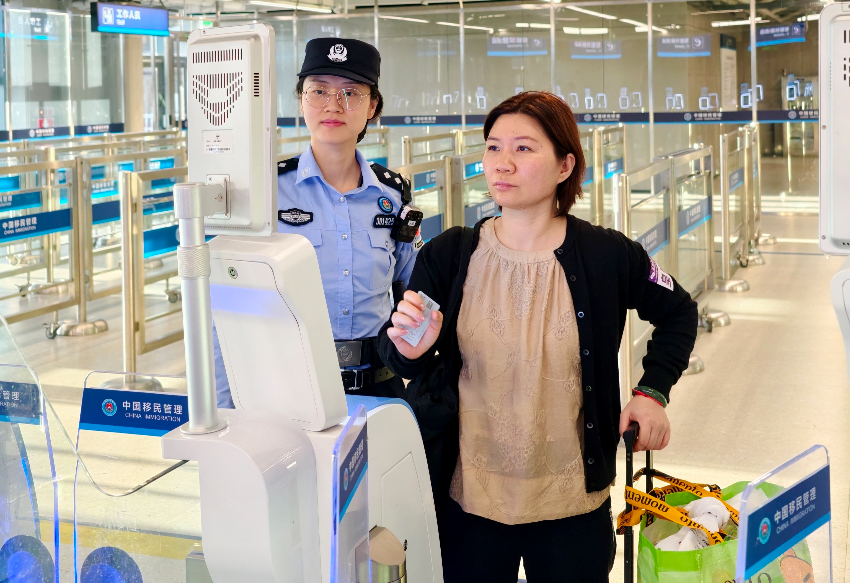 皇崗邊檢站民警指導(dǎo)首次經(jīng)智能快捷通道入境香港旅客“刷臉”代替“刷證”體驗(yàn)。 通訊員 黃俊生 供圖