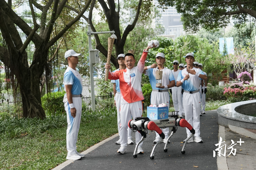 1月2日上午，十五運會火炬?zhèn)鬟f活動上“機器狗”現(xiàn)身深圳，將全運會吉祥物交給火炬手。