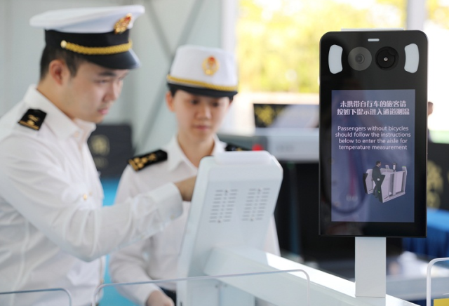為迎接自行車（公路）賽男子個人賽（十五運會唯一跨越粵港澳三地的標志性賽事），拱北海關關員對體溫檢測閘機進行測試。來源：海關總署