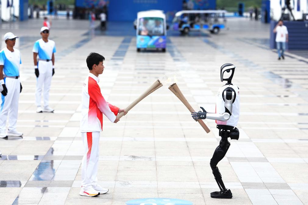 11月2日，火炬手人形機(jī)器人“夸父”與王裕寧（左）在深圳站火炬?zhèn)鬟f中。