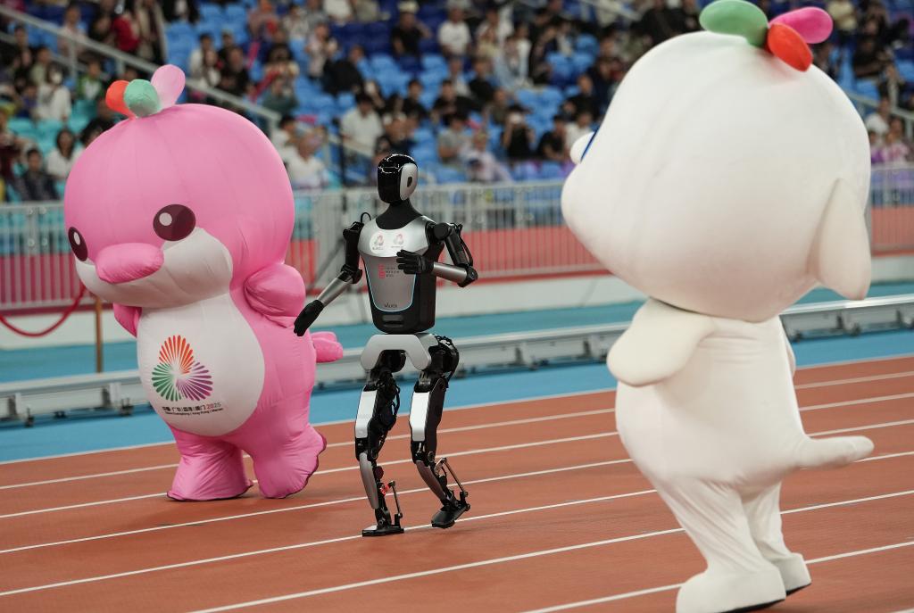 11月17日，在田徑項目賽事開始前的暖場活動中，機器人和吉祥物喜洋洋、樂融融在廣東奧體中心體育場賽跑。
