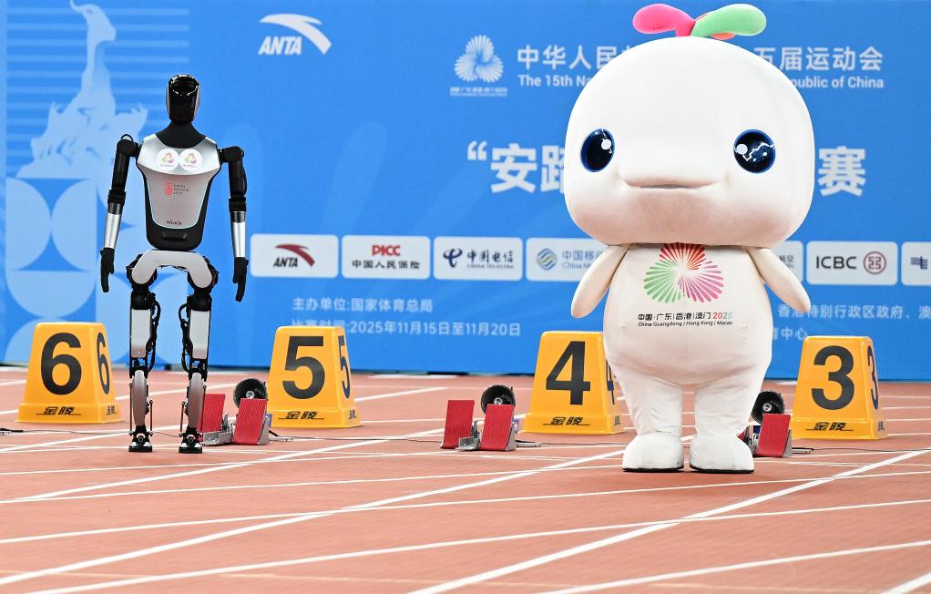 11月17日，在田徑項(xiàng)目賽事開(kāi)始前的暖場(chǎng)活動(dòng)中，機(jī)器人和吉祥物喜洋洋在廣東奧體中心體育場(chǎng)賽跑。