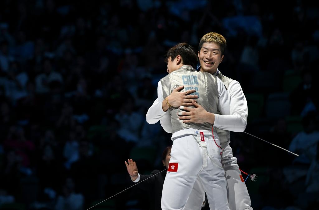 11月19日，香港隊選手蔡俊彥（左）和隊友張家朗在比賽后相擁慶祝奪冠。新華社記者 胡虎虎 攝