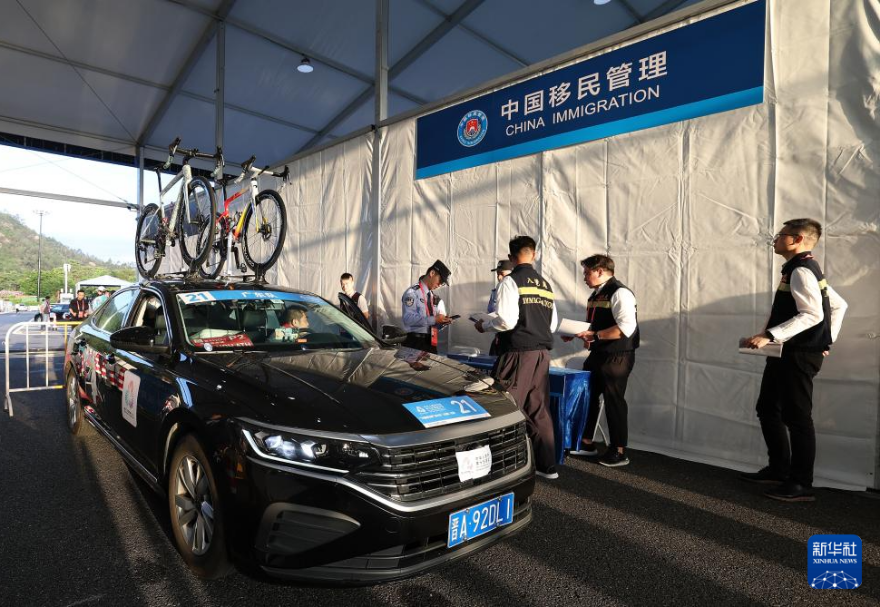 公路自行車賽涉賽車輛、物資都采用“前置查驗+閉環管理”監管模式。參賽團隊提前報審形成“白名單”，在運動隊啟動之前進行核檢，確保涉賽車輛、物資能在三地暢通無阻。圖為公路自行車男子個人賽參賽代表團在前置安檢區安檢。