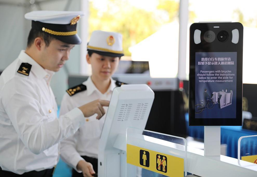 公路自行車賽在比賽起點和終點設置海關查驗區，在開賽前和完賽后集中完成海關進出境人員衛生檢疫。圖為關員對體溫檢測閘機進行測試。