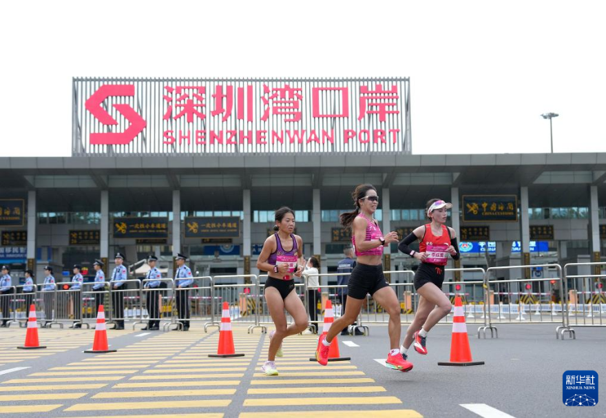十五運會馬拉松項目是全運會歷史上首場跨境馬拉松賽事，運動員從起跑到完賽，其生物特征與實時位置數據已與后臺系統同步融合，比賽參賽選手無需改變自己的節奏，在奔跑中便完成了跨境通關。圖為十五運會女子馬拉松比賽參賽選手經過深圳灣口岸。