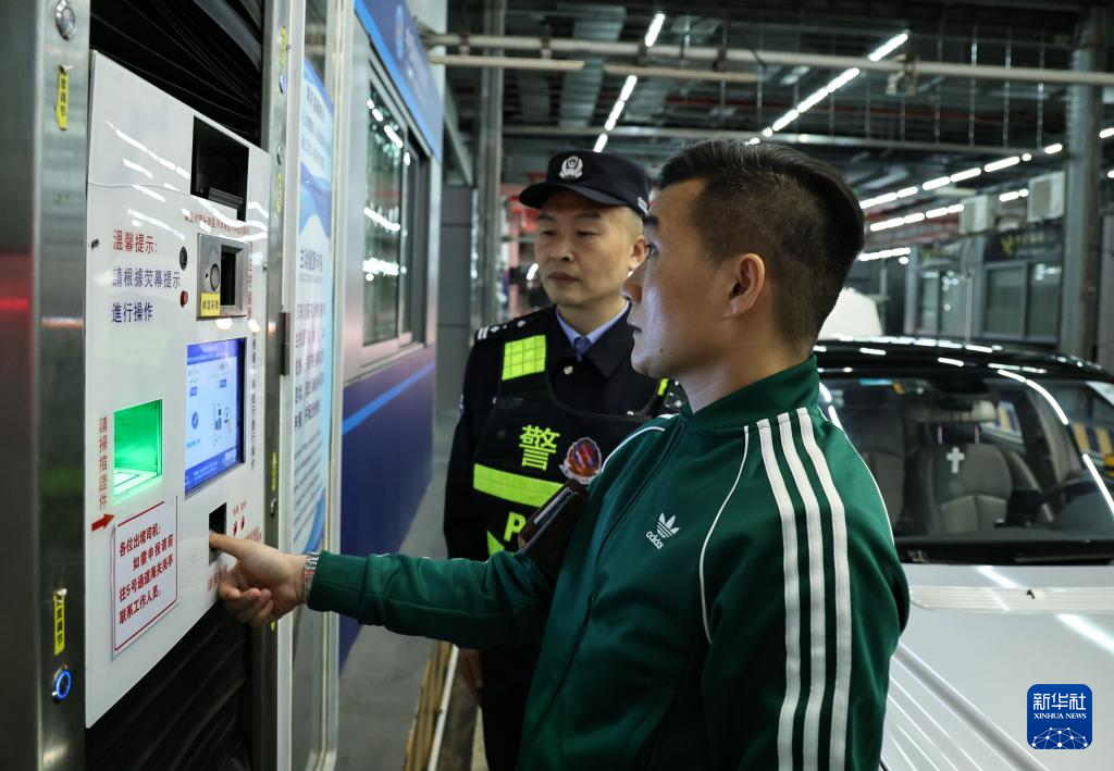 12月23日零時，“粵車南下”入境香港市區的通關車主曹先生（前）在“一站式”通道辦理通關手續。新華社記者 黃國保 攝