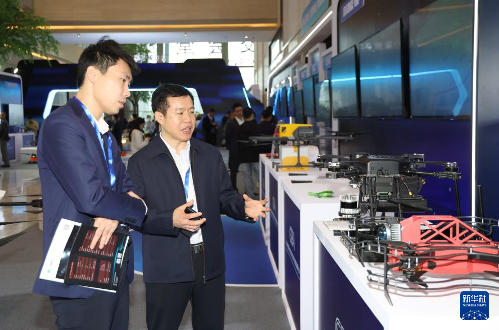 12月25日，與會(huì)人士在大會(huì)展覽區(qū)參觀、交流。新華社記者 盧漢欣 攝