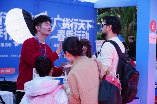 在“廣貨行天下”春季行動消費電子專場促銷活動現場，國外游客與商家交談。新華社記者 王豐 攝