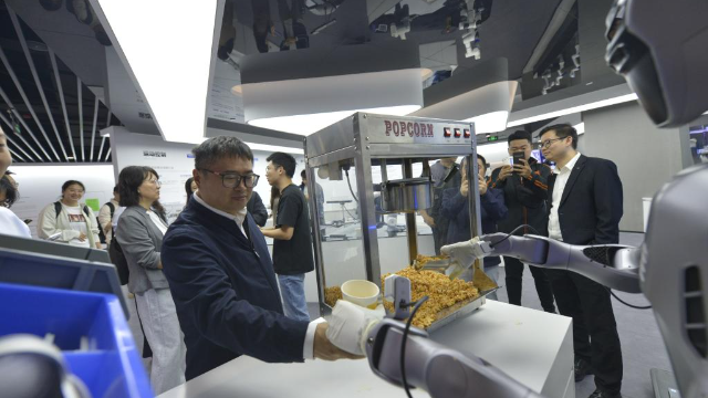 2025年10月29日，在廣東深圳越疆科技有限公司，機器人為記者裝爆米花。新華社記者 劉力航 攝