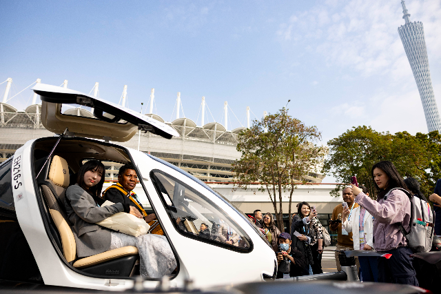 外賓登上億航無人駕駛載人航空器的駕駛座體驗拍照。 南方+ 梁鉅聰 拍攝