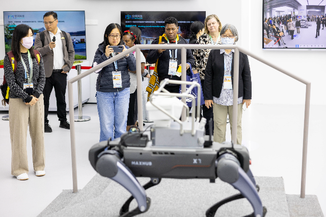 外賓們參觀并體驗四足機器狗的各種功能。 南方+ 梁鉅聰 拍攝