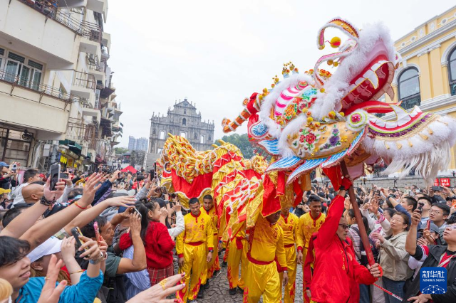 2月17日，舞龍隊伍在澳門大三巴牌坊前與市民互動。 新華社發(fā)（張金加攝）