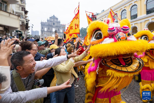 2月17日，舞獅隊伍在澳門大三巴牌坊前與市民互動。 新華社發(fā)（張金加攝）