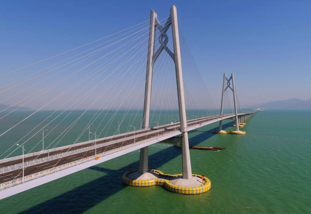 港珠澳大橋主體工程實行橋、島、隧于一體，總長約29.6公里，穿越伶仃航道和銅鼓西航道段約6.7公里為隧道，東、西兩端各設置一個海中人工島（藍海豚島和白海豚島），猶如“伶仃雙貝”熠熠生輝；其余路段約22.9公里為橋梁，分別設有寓意三地同心的“中國結”青州橋、人與自然和諧相處的“海豚塔”江海橋，以及揚帆起航的“風帆塔”九洲橋三座通航斜拉橋。圖為寓意三地同心的“中國結”青州橋。